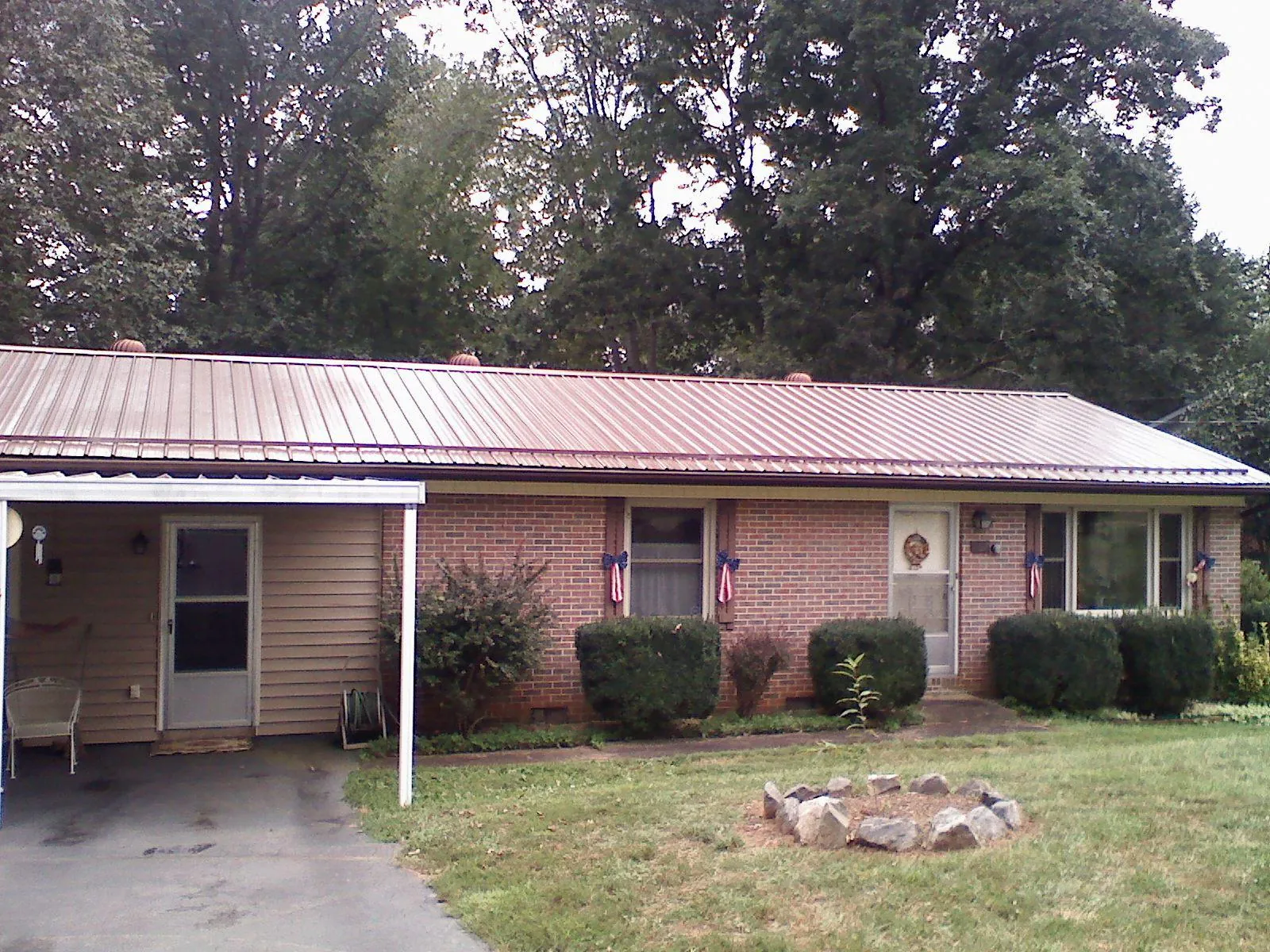 Bronze metal roof and carport on a brick ranch home — Roof Repair work by our crew in Clint